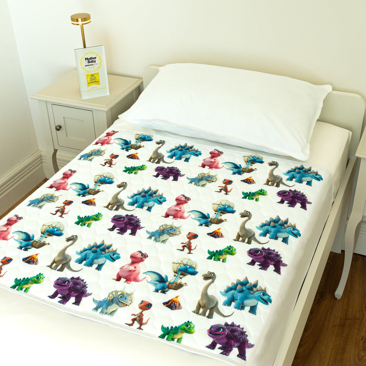 Bedwetz Dinosaur waterproof bed pad on a single bed with the Mother&Baby Awards 2026 Gold trophy